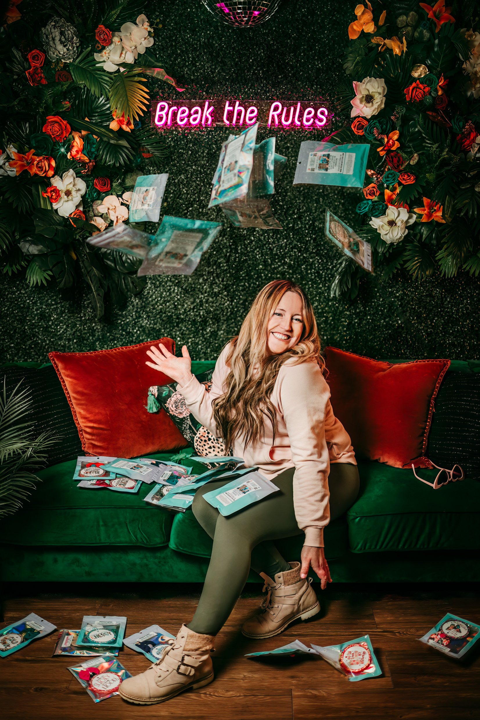 woman sitting on green couch throwing her air fresheners up and posing for a branding photography photo